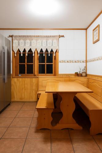 a kitchen with a table and benches in it at Hospedaje de la Abu in Coihaique