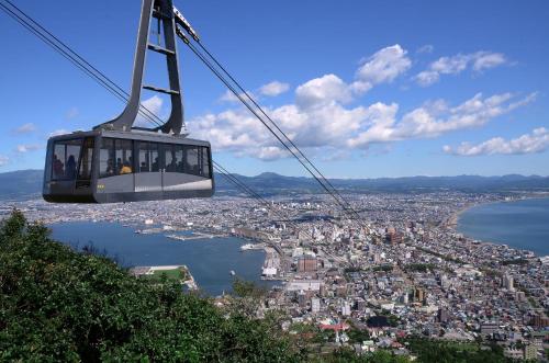 a gondola is flying over a city at ステラサイト函館 in Hakodate