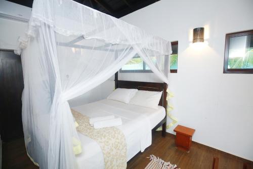 a bedroom with a bed with a canopy at Ocean Soluna Beach Villa in Tangalle
