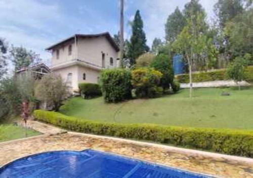 a house with a swimming pool in front of a yard at WJL Sitio Silva in Ibiúna