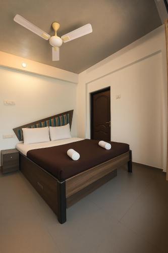 a bedroom with a bed with a ceiling fan at The Grantley Hotel - Alibag Beach in Alibag