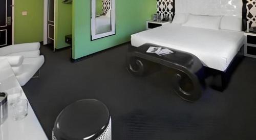 a bedroom with a bed and a chair and a table at Cabana Suites at El Cortez in Las Vegas
