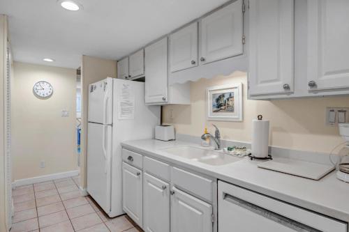 a kitchen with white cabinets and a white refrigerator at Beachy Vibes in Ponte Vedra Beach