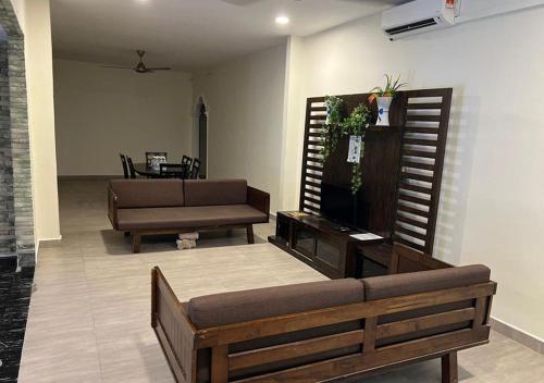 a living room with a couch and a tv at D'Lima Beach Inn in Pantai Cenang