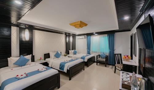 a room with three beds with blue pillows at The Sanctuary Residence in Siem Reap