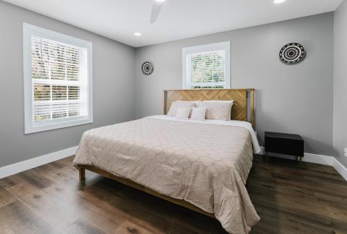 a bedroom with a large bed and two windows at Modern Renovated 3-Bed Near Ann Arbor & Ypsilanti in Ypsilanti