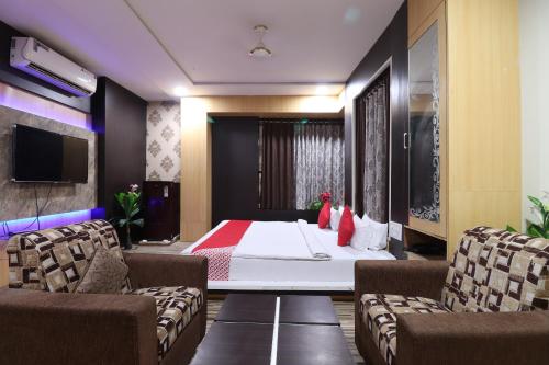 a hotel room with a bed and two chairs at Hotel O Shri Sai Niwara Lodge in Dhule