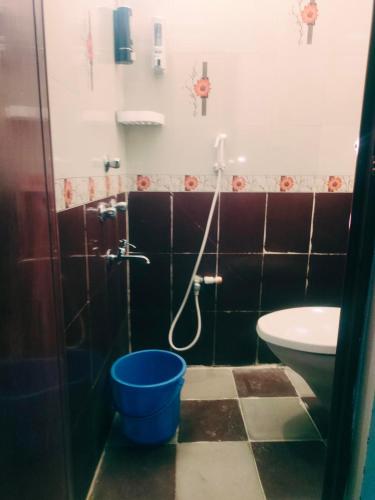 a bathroom with a shower and a toilet and a bucket at DREAMY cosy stay 4bhk, 6 mins to Whitetown & Beach - COPPER in Puducherry