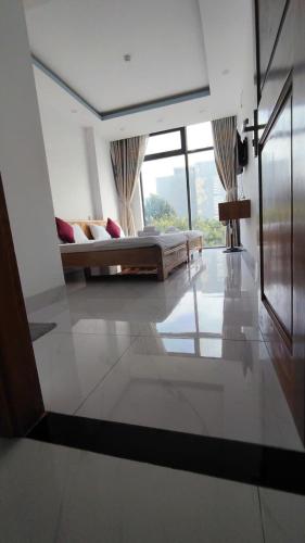 un salon avec un canapé et une grande fenêtre dans l'établissement HomeStay Khánh Linh B1 Hồ Quý Ly, à Vung Tau
