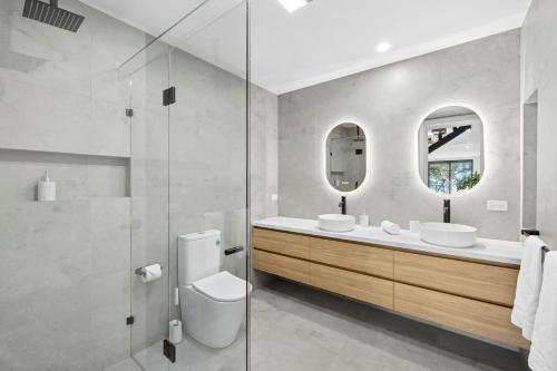 a bathroom with two sinks and a glass shower at Eleve Lorne in Lorne