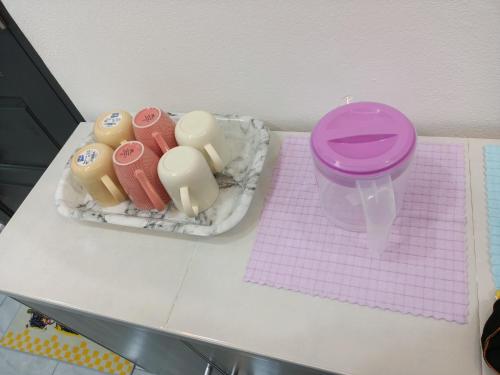 a table with a pink cup and other toys on it at The Pesona Beach House in Bachok