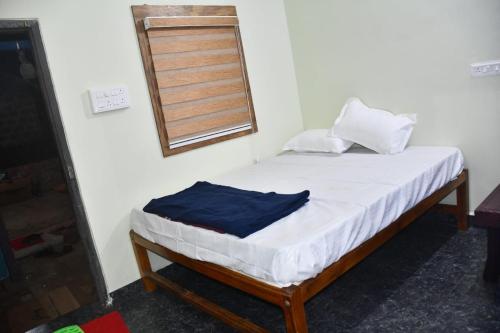 a small bed in a room with a window at Golden Kudle Beach Resort in Gokarna