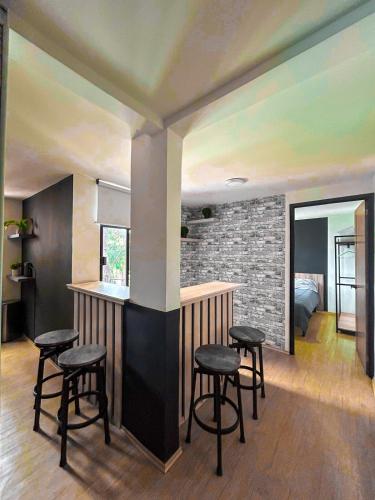a kitchen with a bar with stools in a room at Departamento Junto a la Feria de Pachuca in Pachuca de Soto