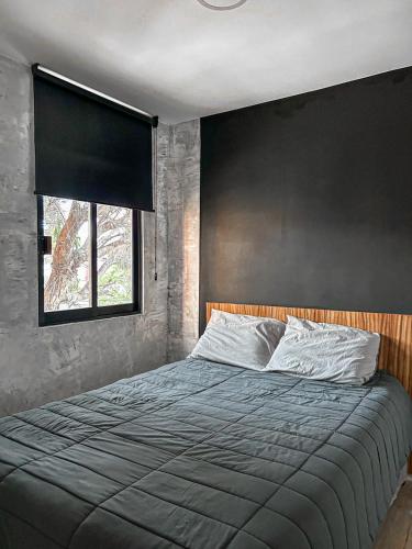 a bedroom with a large bed with a black wall at Departamento Junto a la Feria de Pachuca in Pachuca de Soto