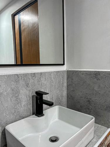 a bathroom sink with a faucet and a mirror at Departamento Junto a la Feria de Pachuca in Pachuca de Soto