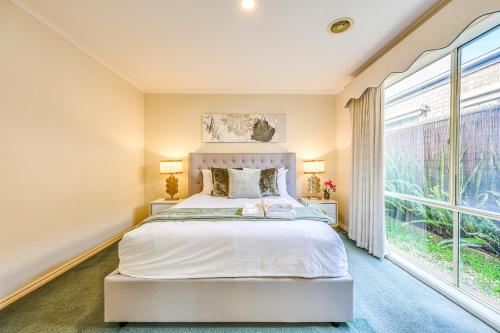 a bedroom with a bed and a large window at StayAU Family Retreat with Pool Table in Cranbourne in Cranbourne