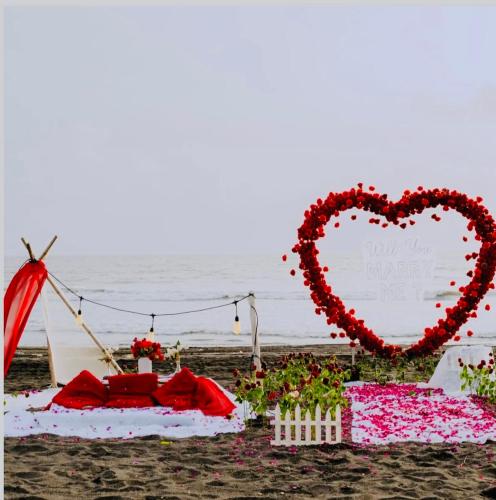 a heart sign on the beach with a table with flowers at Sea royal beach cafe in Virār