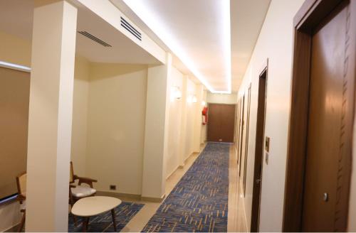 a hallway of a hospital with a chair and a table at Kadamb Kuteer Vrindavan in Chhatikara