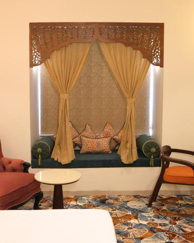 a living room with a bed with a curtain at Kadamb Kuteer Vrindavan in Chhatikara