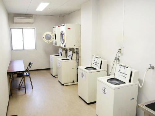 a room with white appliances in a room with a window at Shimoda Itoen Hotel Hanamisaki in Shimoda