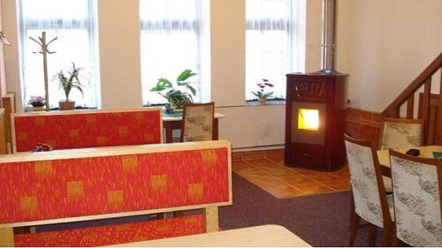 a dining room with a table and chairs and a fireplace at Pension Lípa in Horní Maršov