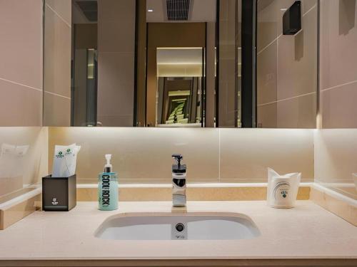 a bathroom with a sink and a mirror at City Comfort Inn Hotel Dongguan Humen Pedestrian Street in Dongguan