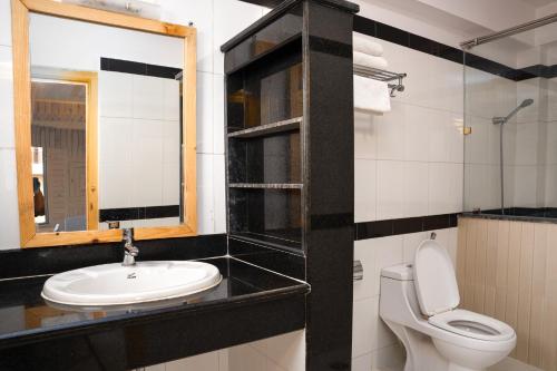 a bathroom with a sink and a toilet and a mirror at Trekkers Inn Boutique Hotel Pokhara in Pokhara