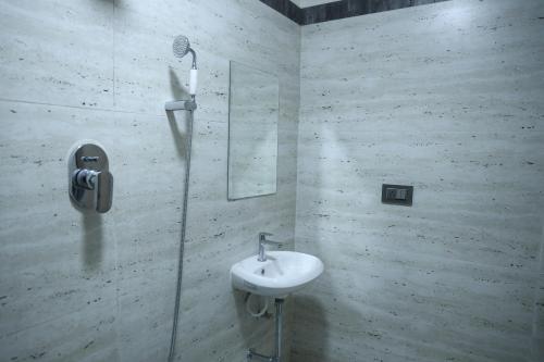 a white bathroom with a sink and a mirror at pvp inn in Ārani