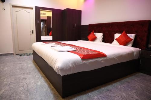 a bedroom with a large bed with red pillows at pvp inn in Ārani