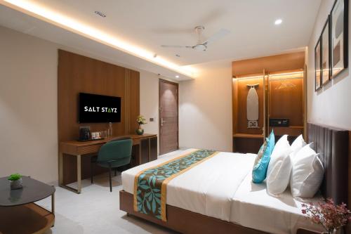 a hotel room with a bed and a desk at Saltstayz Premier - Naraina, Central Delhi in New Delhi