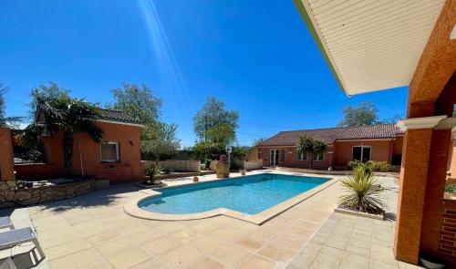 a swimming pool in a yard with a house at L'Hacienda Soléa in Culmont