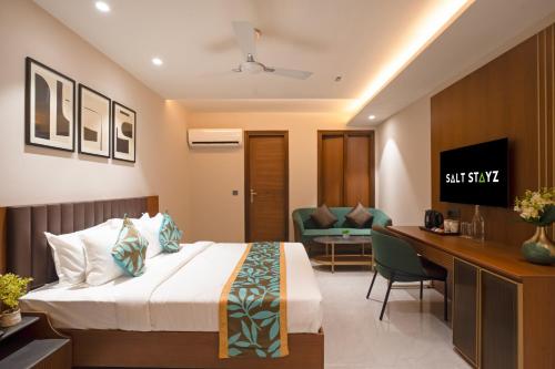 a hotel room with a bed and a desk at Saltstayz Premier - Naraina, Central Delhi in New Delhi