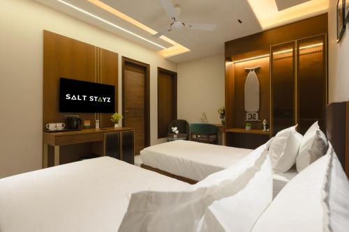 a hotel room with two beds and a mirror at Saltstayz Premier - Naraina, Central Delhi in New Delhi