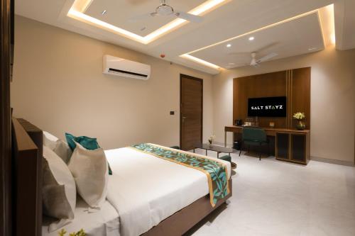 a bedroom with a bed and a desk in a room at Saltstayz Premier - Naraina, Central Delhi in New Delhi