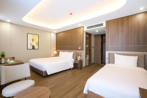 a hotel room with two beds and a desk at Nature Hotel - Lac Long Quan in Hanoi