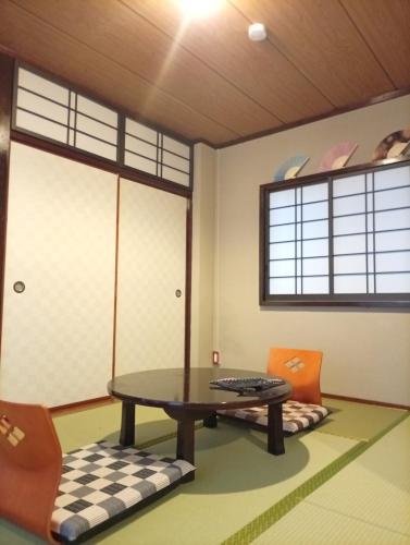 a room with a table and chairs and a window at Oyadoya-Ebisu 102 in Wada