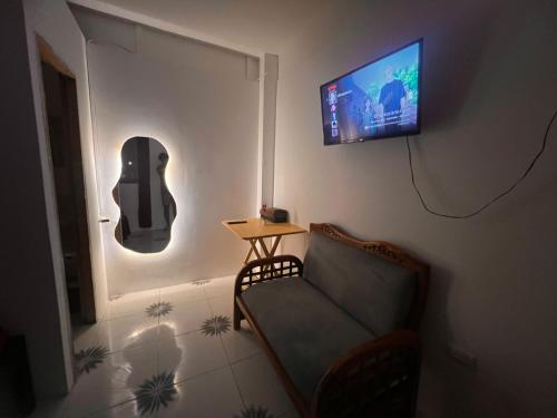 a living room with a couch and a flat screen tv at UFO Rooms in Montañita