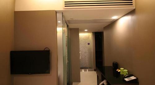 a bathroom with a mirror and a television in a room at J Link Hotel in Hong Kong