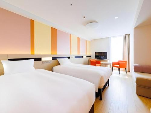 a hotel room with two beds and a desk at Hotel Dream Gate Maihama Annex in Chiba