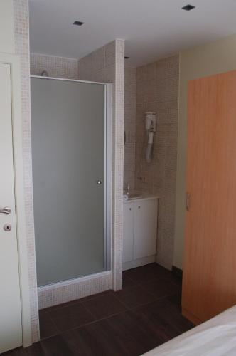 a bathroom with a sliding glass door and a sink at B&B Bloemenweelde in Kortrijk