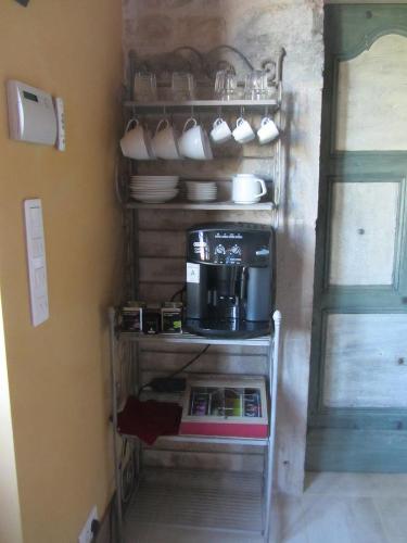 a shelf with a coffee maker in a kitchen at Le relais des deux tours in Brémondans