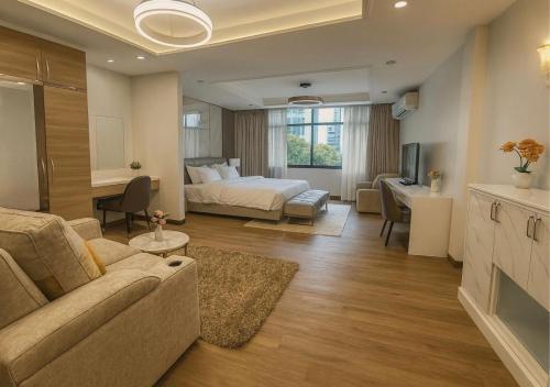 a living room with a couch and a bed at Solumie Boutique Hotel in Bangkok