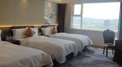 a hotel room with two beds and a window at Yanji Yanbian International Hotel in Yanji