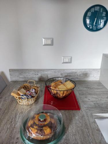 een tafel met een bord eten en manden brood bij La tana della Fenice in Labico