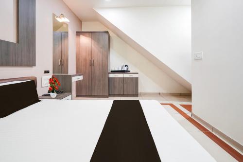 a large room with a bed and a sink at Super Collection O Sachivalaya Metro Station Gandhinagar Formerly Hotel Ghunghat Inn in Gandhinagar