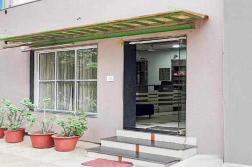 a front door of a house with potted plants at Super Collection O Sachivalaya Metro Station Gandhinagar Formerly Hotel Ghunghat Inn in Gandhinagar