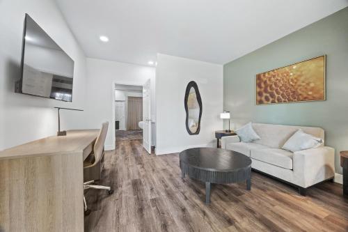 a living room with a couch and a table at University Park Inn & Suites, an Ascend Collection Hotel in Davis