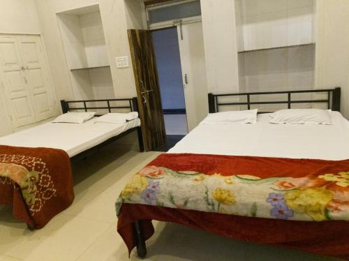 two beds sitting next to each other in a room at Sri Rawatpura sarkar seva ashram in Haridwār