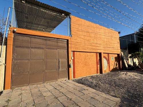 an orange building with two garage doors on it at Lugar encantador con chimenea in Mexico City