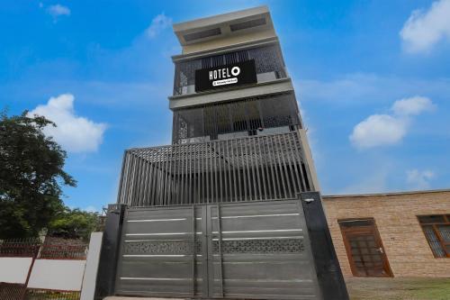 a tall clock tower with a sign on it at Super Hotel O Maharshi Valmiki International Airport Formerly Gaurav Inn in Faizābād